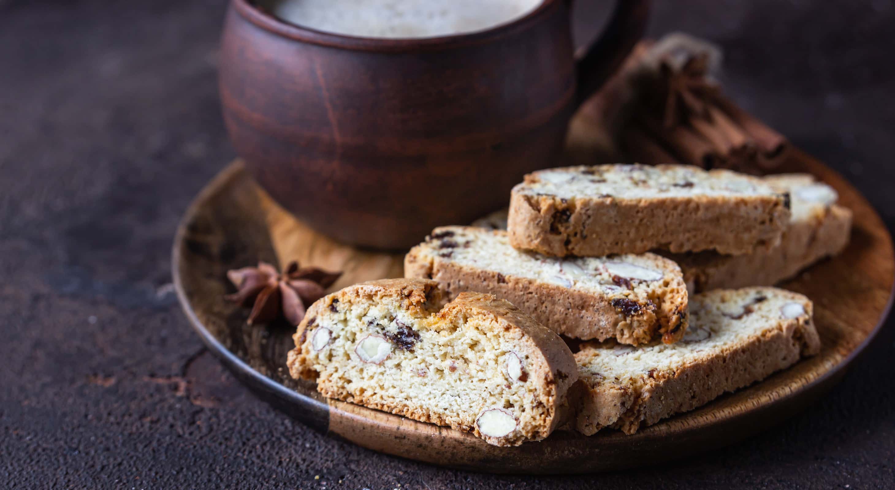 Almond biscotti on a wooden plate served with coffee