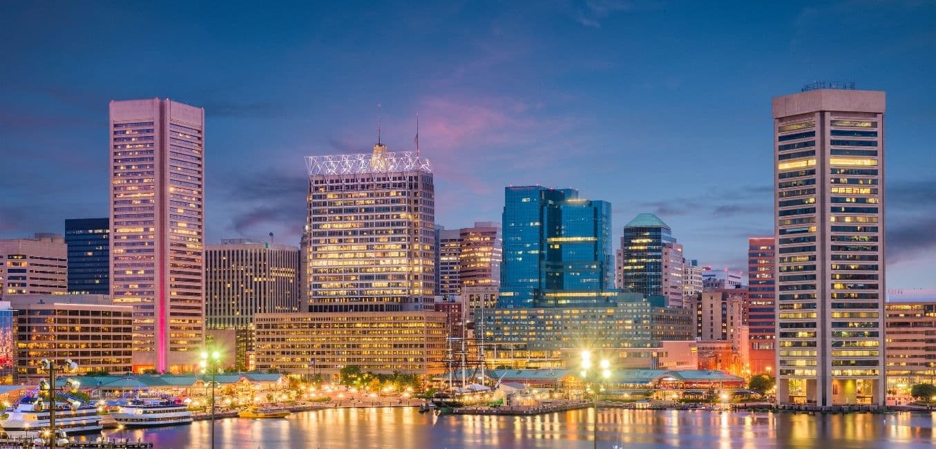 baltimore skyline by the harbor at twilight with city lights glowing 