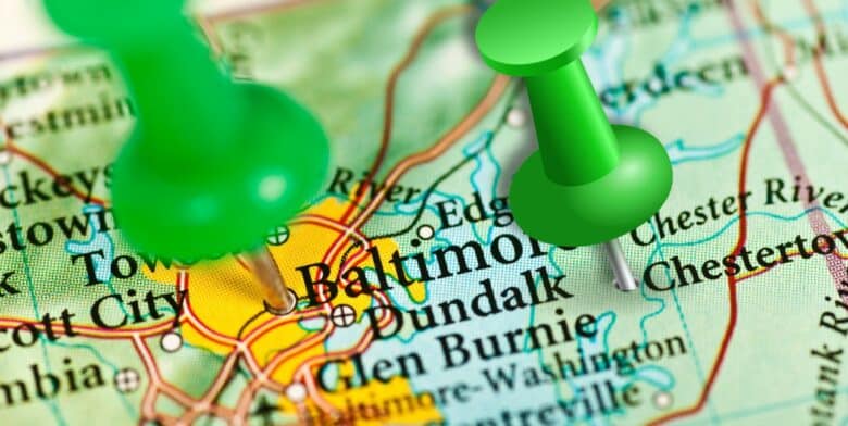 closeup of maryland map with green push pin on baltimore and one on chestertown