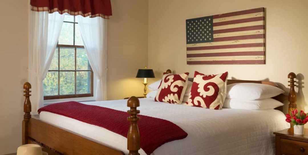 King bed in the Red Room at Brampton Inn with an American Flag wall art