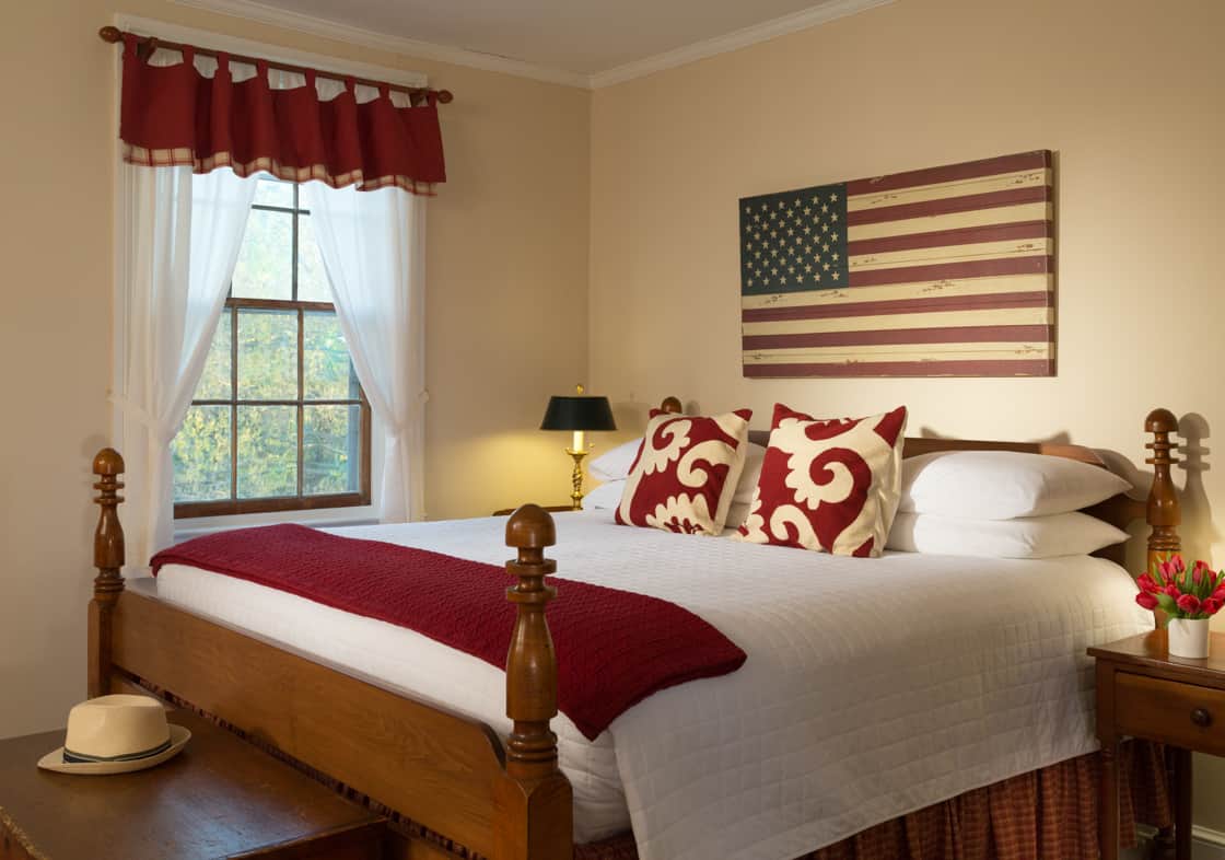 King bed in the Red Room at Brampton Inn with an American Flag wall art