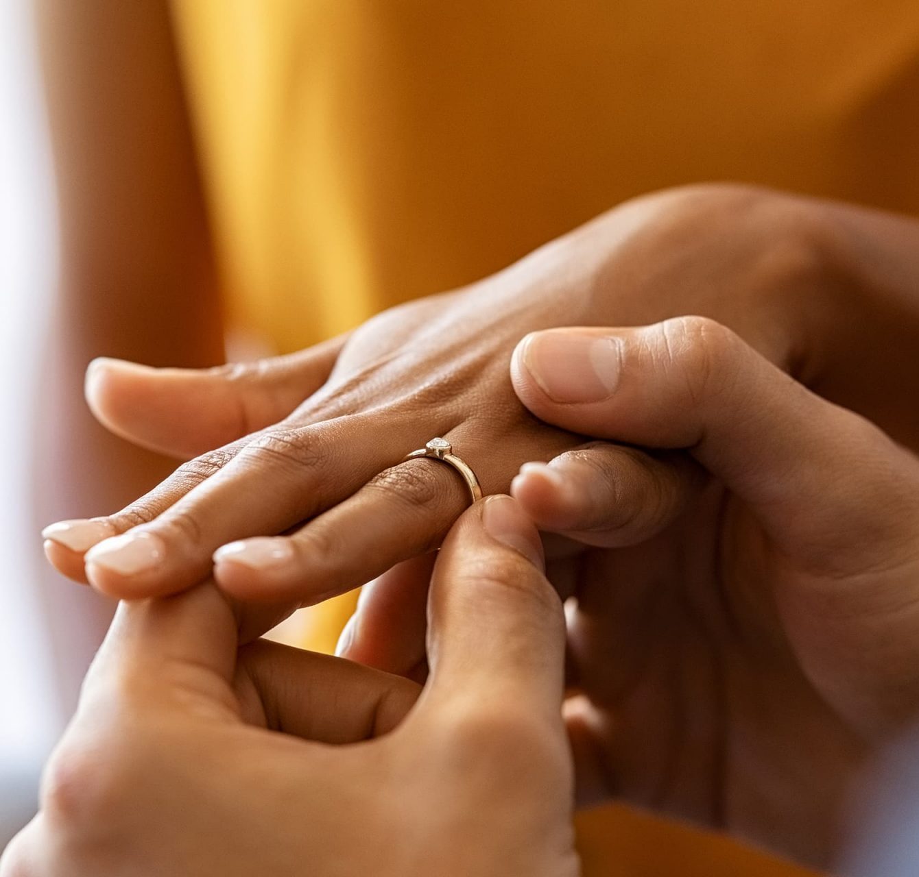 man placing ring on finger at wedding