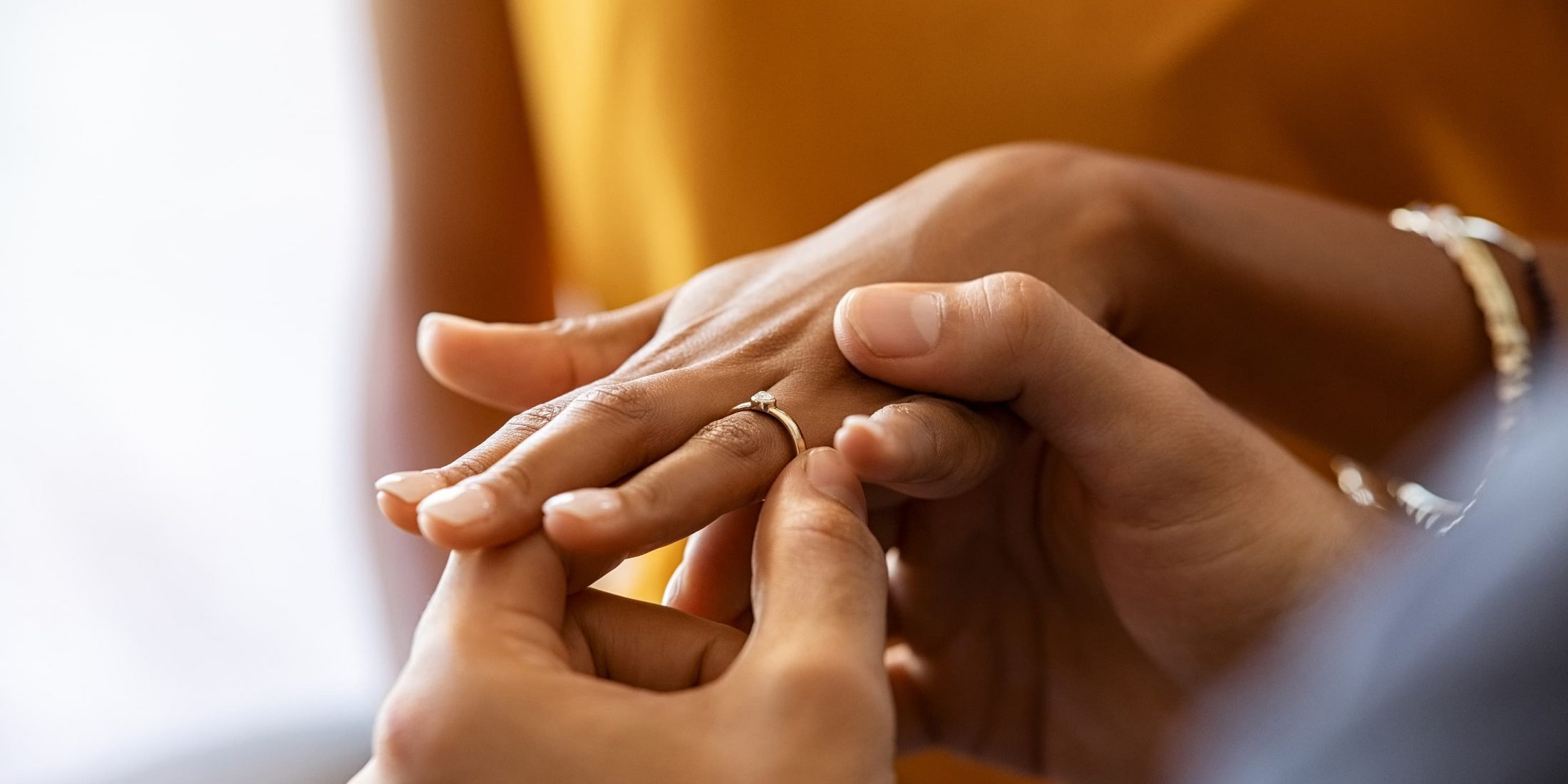 man placing ring on finger at wedding
