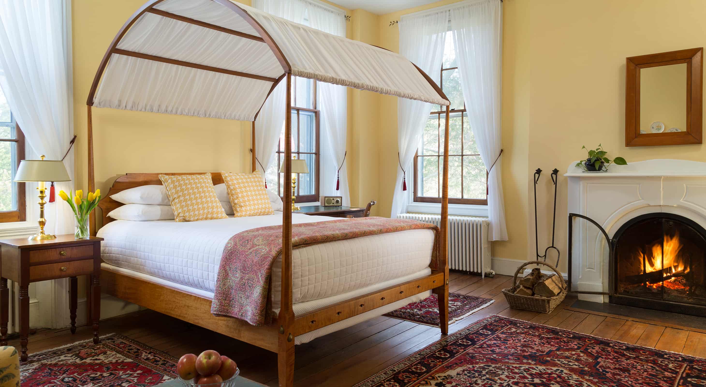 Yellow room canopy bed and fireplace
