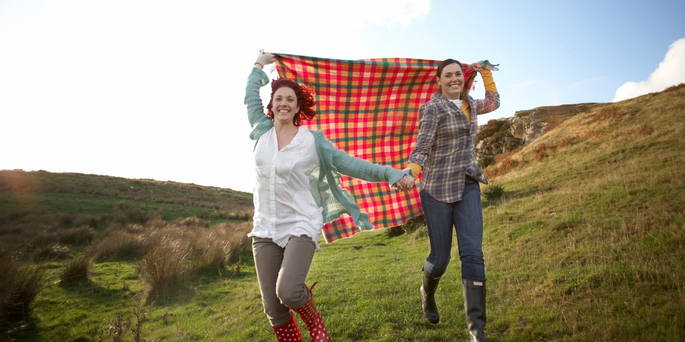 couple running with picnic blanket