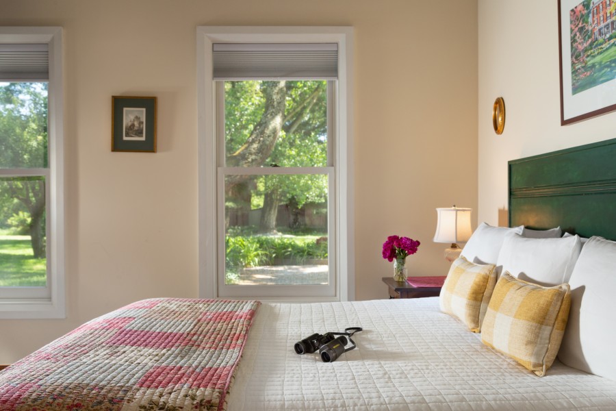 Spacious guest room with windows overlooking the green gardens