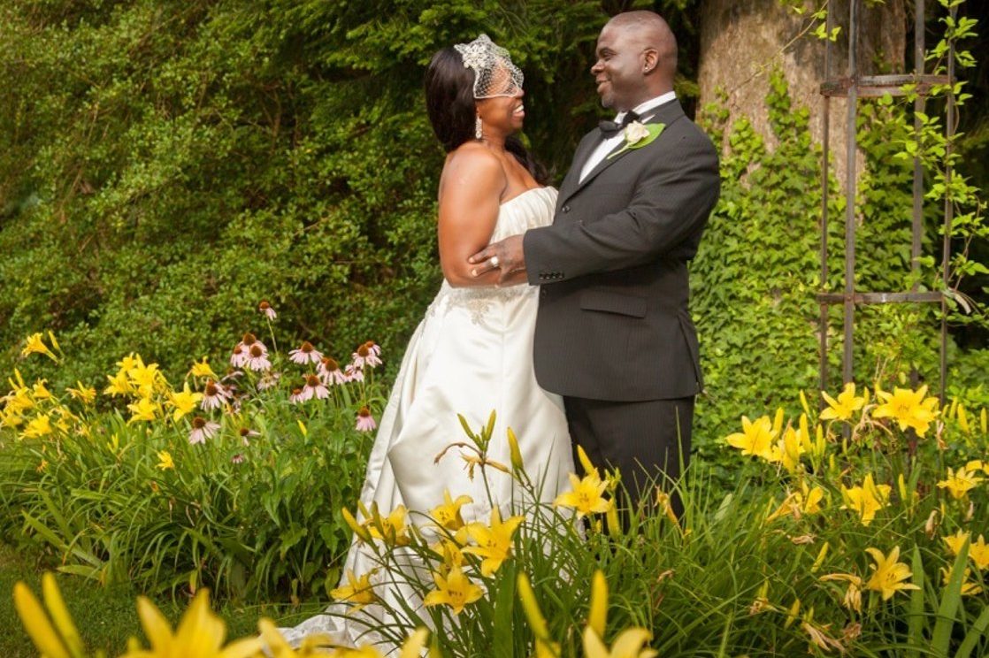bride and groom standing among lillies