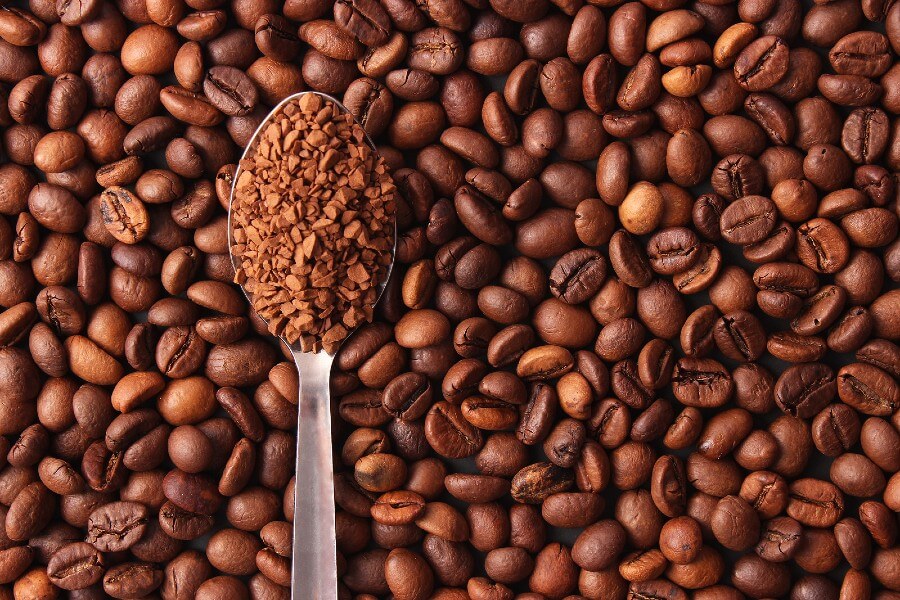 coffee beans and spoonful of instant coffee