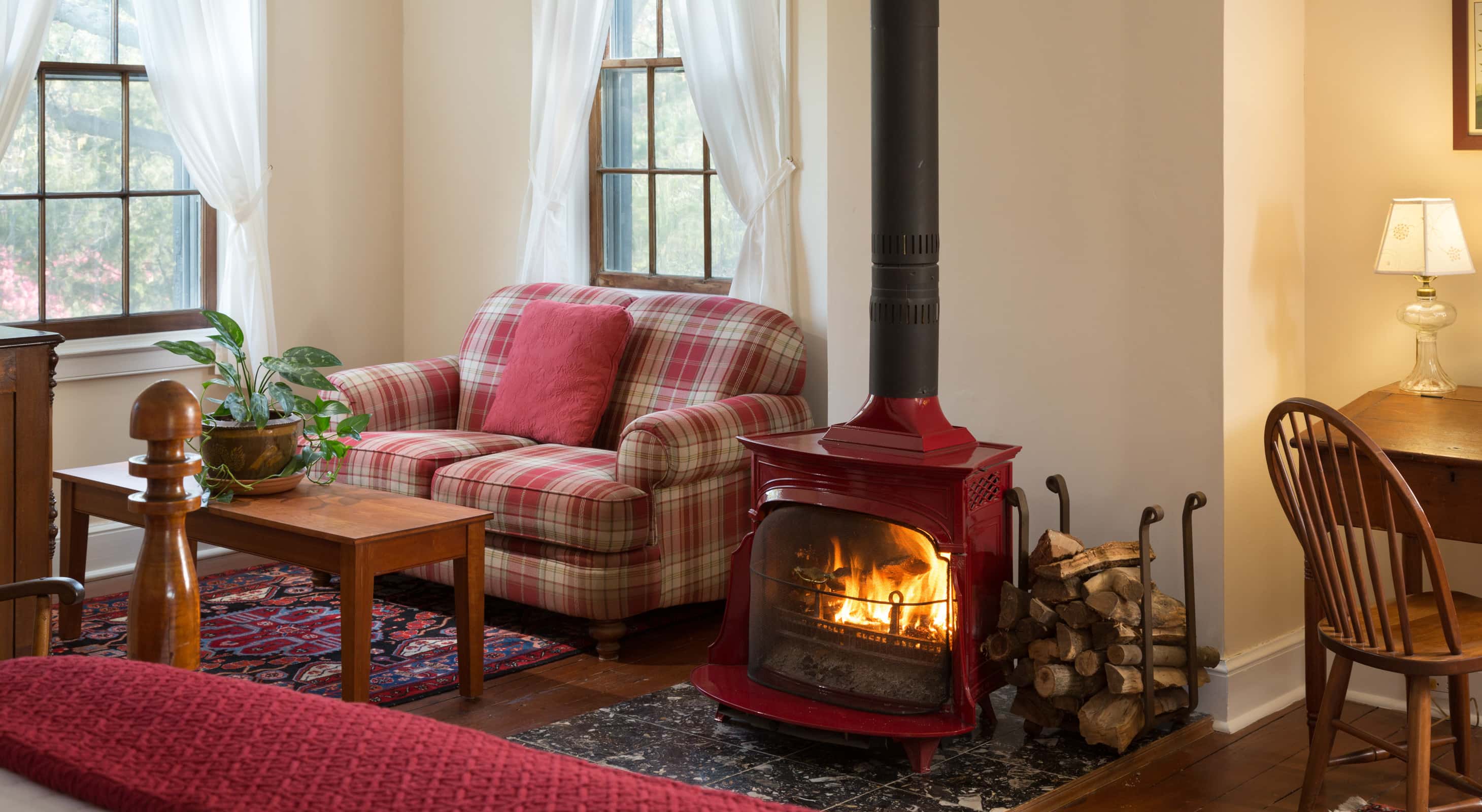 red room at brampton Inn with a sitting area and a wood-burning stove
