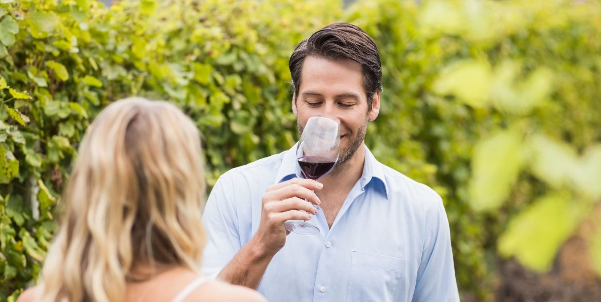 man and woman tasting wine in a vineyard
