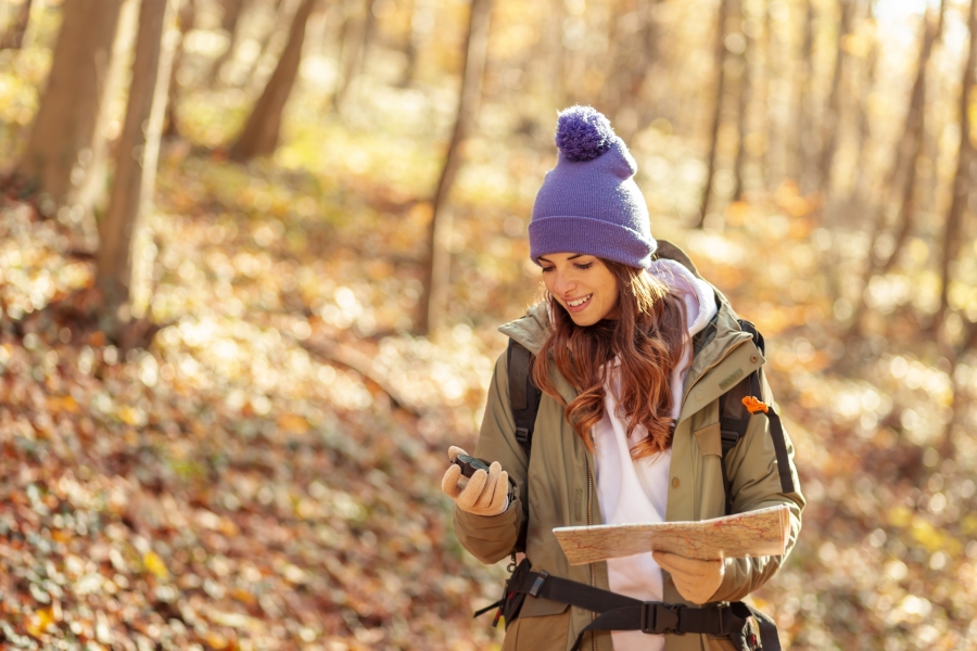 a woman hiking surrounded by fall foliage on a getaway in Maryland