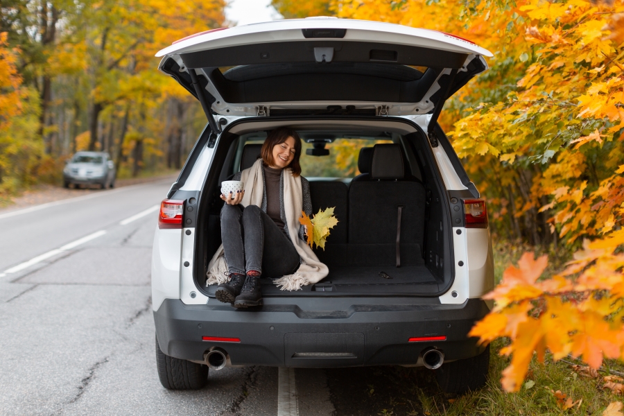 a woman in a car stopped by the side of the road for fall foliage on Maryland scenic byway