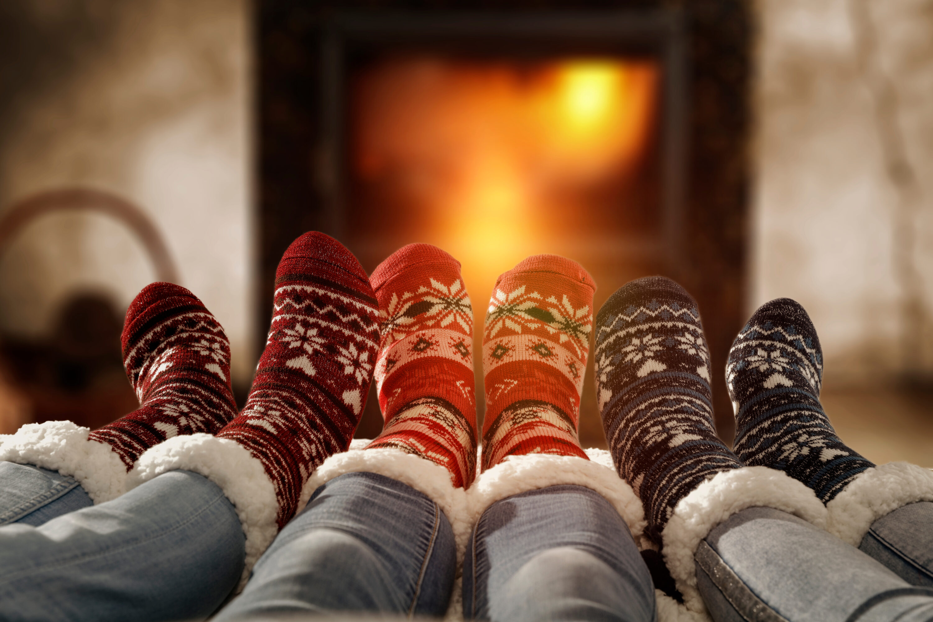 Women's feet in festive slippers in front of fireplace