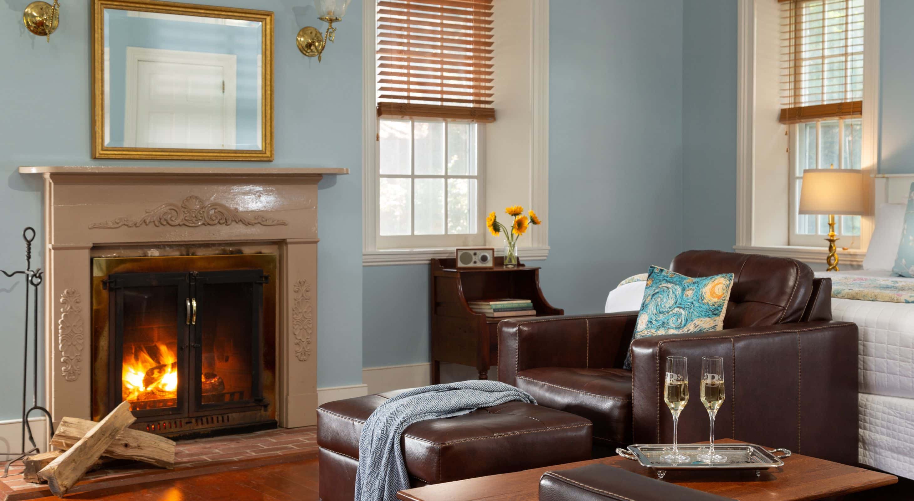 Light blue Sunrise room with natural light, fireplace, wood floors, and leather furniture