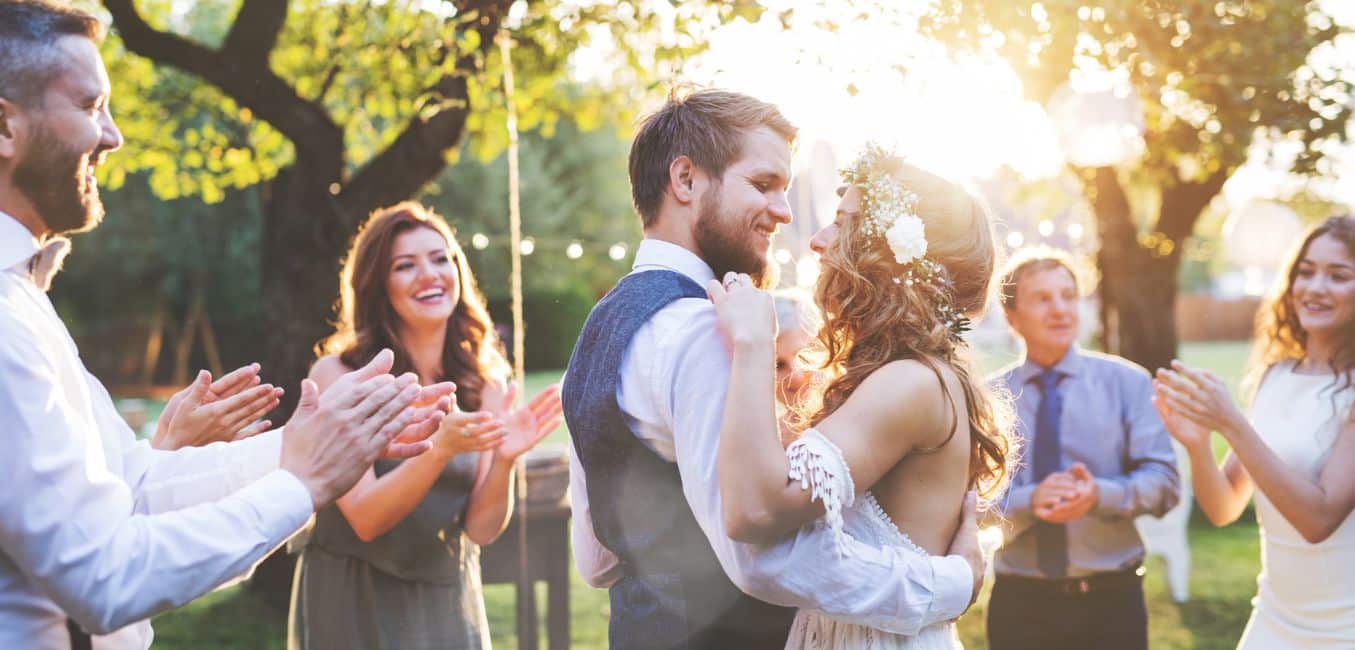 a bride and groom dancing in the center of their friends 