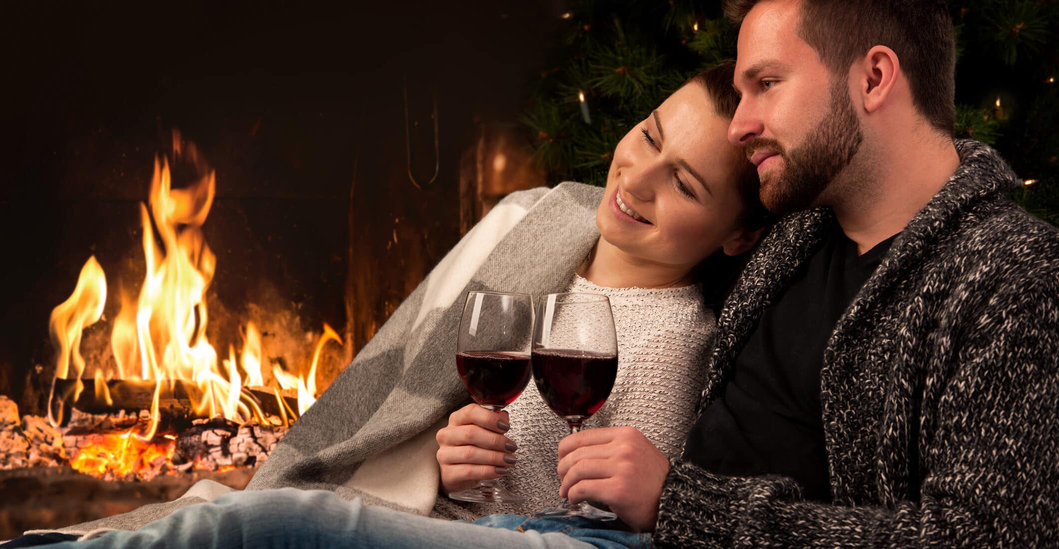 Couple with glass of wine at fireplace