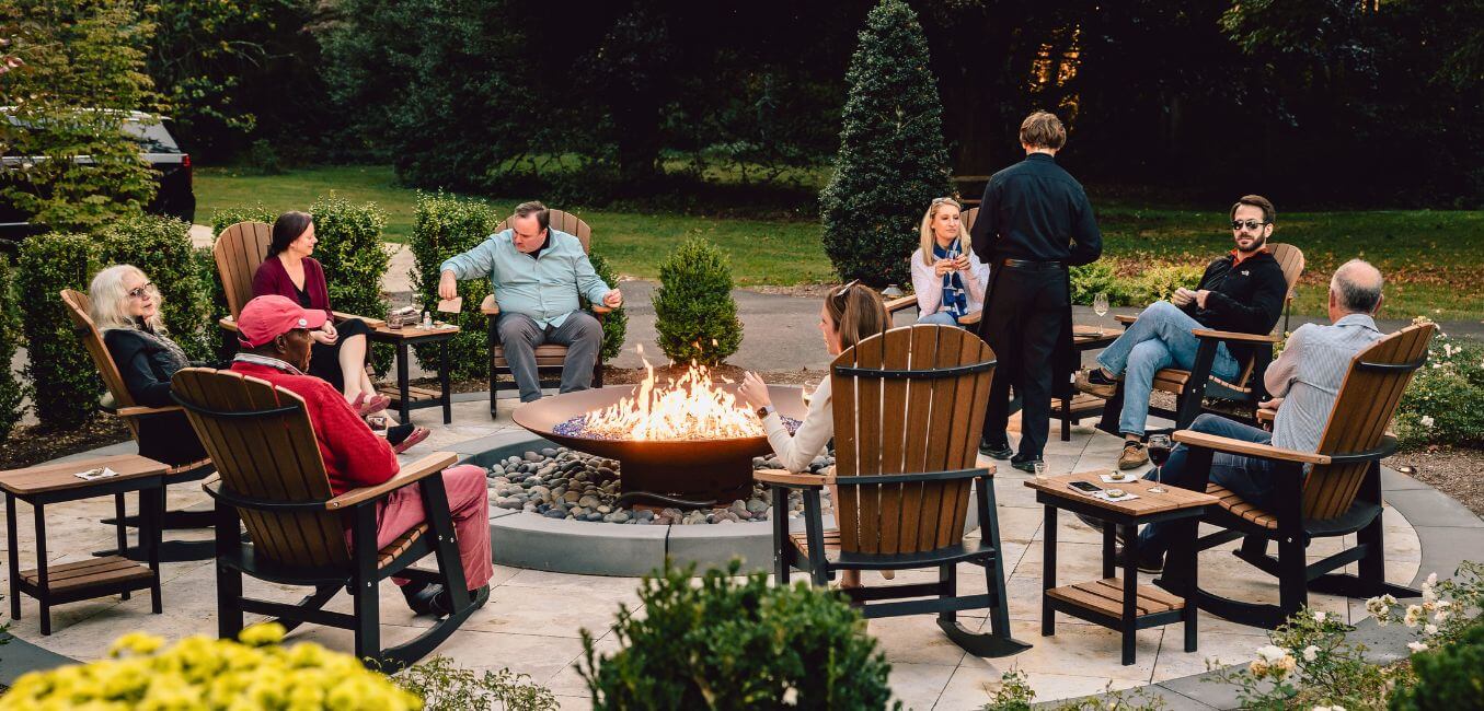 guests sitting around firepit at brampton 1860 chatting