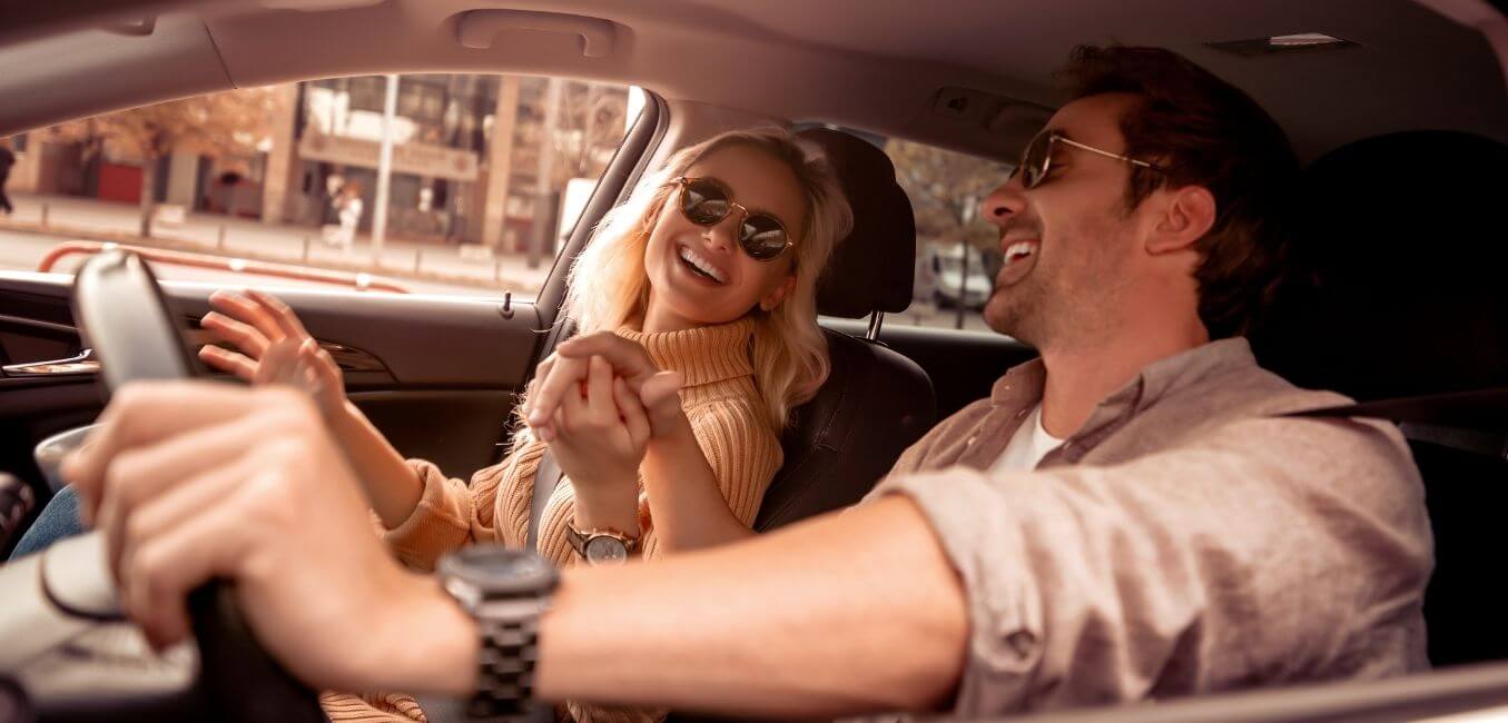 couple laughing while driving in a car